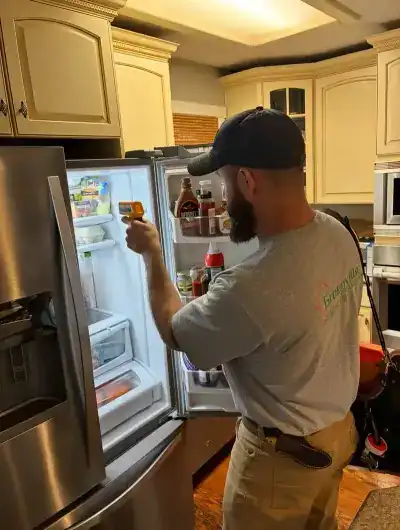 Blake Miller diagnosing a refrigerator that isn't cooling properly